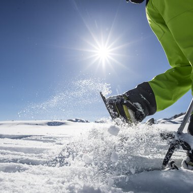 © Kleinwalsertal Tourismus | Dominik Berchtold A sunny day in the snow with a person working in the snow with a ski pole. In the background, another person can be seen. | © Kleinwalsertal Tourismus | Dominik Berchtold