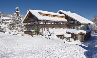 A beautiful, snow-covered chalet in the mountains. The clear blue sky creates a nice contrast to the winter landscape. | © Alpahotel Walserstuba GmbH | Cocett