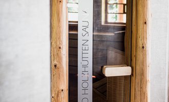 Ein moderner Eingang zu einem Raum mit Holzrahmen und gläserner Tür. Der Platz vermittelt eine einladende und entspannende Atmosphäre. | © Verwöhn- & Wellnesshotel Walserhof| Aileen Melucci