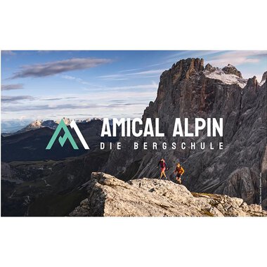 Zwei Personen wandern auf einem Felsen mit Blick auf beeindruckende Berge. Der Logo von "Amical Alpin" ist prominent im Bild platziert. | © SALEWA | Fotograf Storvteller Labs