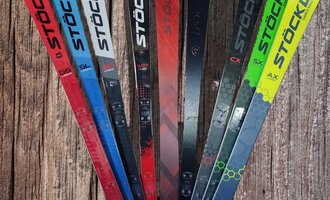 © Austrian Ski- & Service Ranch | Trixi Leitner Eine Auswahl an Skiern von Stöckli in verschiedenen Farben. Die Skier stehen aufrecht und zeigen ihre markanten Designs. | © Austrian Ski- & Service Ranch | Trixi Leitner