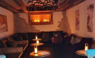 © Hotel Steinbock Ein gemütlicher Raum mit einer warmen Atmosphäre. Es gibt bequeme Sitze und sanftes Licht von Kerzen. | © Hotel Steinbock