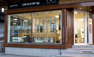 Ein Optikgeschäft mit großen Fenstern und einer Auswahl an Sonnenbrillen. Der Laden trägt das Schild "blickfang" und ist modern gestaltet. | © Blickfang | Michael Stumpe
