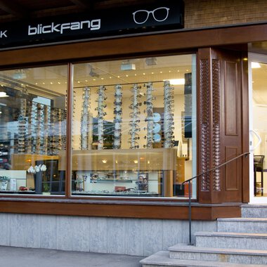 Ein Optikgeschäft mit großen Fenstern und einer Auswahl an Sonnenbrillen. Der Laden trägt das Schild "blickfang" und ist modern gestaltet. | © Blickfang | Michael Stumpe