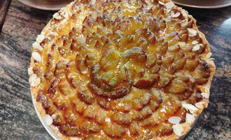 © Kleinwalsertal Tourismus | N. Lughammer A delicious fruit cake with an artful arrangement of fruits and almonds. The golden, glossy surface makes it especially appealing. | © Kleinwalsertal Tourismus | N. Lughammer