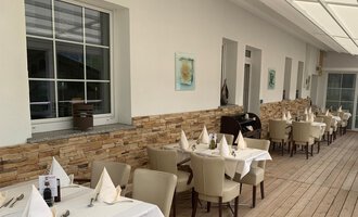 An elegant restaurant with wooden floors and bright tables. The walls are decorated in soft color tones and there are large windows for plenty of daylight. | © Ristorante Trentino | Dietmar Jochum