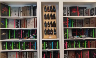 © Chrömle Schönes aus Filz | N. Lughammer A bookshelf with many notebooks in various colors and designs. Below are colored pens and other stationery. | © Chrömle Schönes aus Filz | N. Lughammer