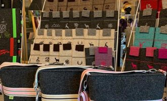 © Chrömle Schönes aus Filz | Anke Drechsel Three stylish felt bags with colorful stripes are in the foreground. In the background, there are additional bags in various colors and designs. | © Chrömle Schönes aus Filz | Anke Drechsel