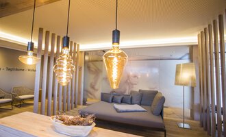 © Genuss- & Aktivhotel Sonnenburg | Frank Drechsel Ein modernes Wohnzimmer mit stilvollen Lichtquellen und gemütlichem Sofa. Die Wände sind hell und der Raum hat eine entspannte Atmosphäre. | © Genuss- & Aktivhotel Sonnenburg | Frank Drechsel