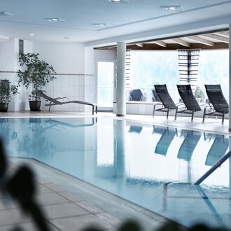 © Hotel Birkenhöhe A bright indoor pool with loungers and plants. The room is designed to be modern and inviting. | © Hotel Birkenhöhe