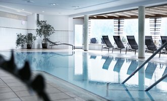 © Hotel Birkenhöhe A bright indoor pool with loungers and plants. The room is designed to be modern and inviting. | © Hotel Birkenhöhe