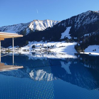 © Hotel Erlebach | Kristin Winter Ein Infinity-Pool mit Blick auf schneebedeckte Berge. Der klare Himmel und die ruhige Wasseroberfläche reflektieren die winterliche Landschaft. | © Hotel Erlebach | Kristin Winter