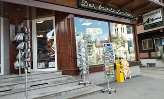 © Der Bunte Laden | Romana Volderauer Ein kleiner Laden mit dem Namen "Der bunte Laden" und einem einladenden Schaufenster. Vor dem Geschäft stehen Verkaufsständer mit verschiedenen Artikeln. | © Der Bunte Laden | Romana Volderauer