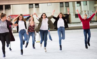 © Sportstätten Oberstdorf | Veronika Lindlbauer A group of cheerful teenagers is skating on an ice rink. They are laughing and having fun while ice skating. | © Sportstätten Oberstdorf | Veronika Lindlbauer