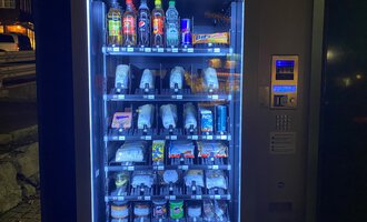 A vending machine with various drinks and snacks. The products are neatly arranged and well-lit. | © Gerd am Herd | Gerd Hammerer