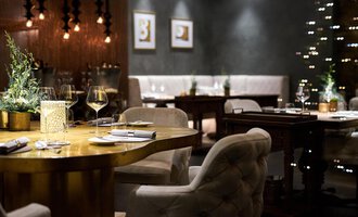 Ein elegantes Restaurant mit geschmackvoller Einrichtung. Der Tisch ist schön gedeckt und die Atmosphäre ist gemütlich und einladend. | © Travel Charme Ifen Hotel