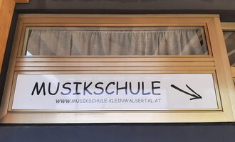 © Kleinwalsertal Tourismus | Veronika Senn A sign with the inscription "MUSIC SCHOOL" points to a music school. The address is also provided. | © Kleinwalsertal Tourismus | Veronika Senn