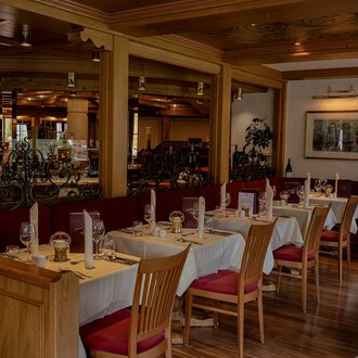 A cozy restaurant with wooden tables and chairs. The decor is warm and inviting, perfect for a pleasant meal. | © IFA Hotel Alpenhof Wildental | Andreas Froschauer