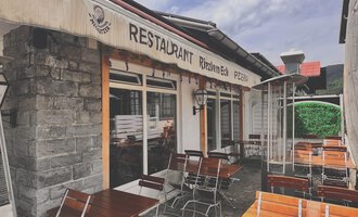 A cozy restaurant with outdoor tables and an inviting atmosphere. The facade is made of stone with a distinctive sign. | © Riezlern Eck | Sead Sulejmani