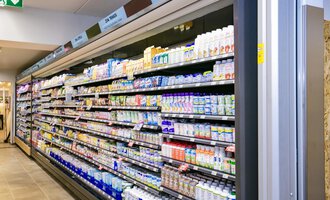 A cooling shelf in a supermarket, filled with various dairy products and beverages. The shelves are well organized and offer a wide selection. | © SPAR