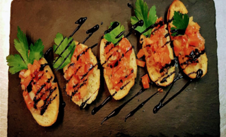 An elegant dish with toasted bread, topped with fresh tomatoes and herbs. Balsamic reduction adds a special touch to it.