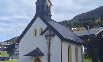 © Unterwestegg-Kapelle Maria Hilf | Tanja Ritsch Eine kleine, weiße Kirche mit einem spitzen Turm und Holzelementen. Im Hintergrund sind grüne Hügel und Bäume sichtbar. | © Unterwestegg-Kapelle Maria Hilf | Tanja Ritsch
