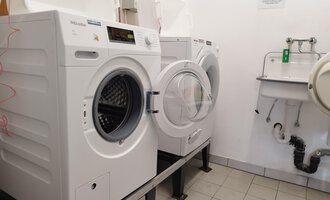 © Kleinwalsertal Tourismus | N. Lughammer Eine Wäschekammer mit mehreren Waschmaschinen auf einem Fliesenboden. Im Hintergrund befindet sich ein Waschbecken. | © Kleinwalsertal Tourismus | N. Lughammer