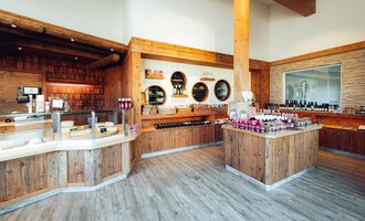 Ein modernes Geschäft mit viel Holzdekor und Regalen voller Produkte. Die gemütliche Atmosphäre lädt zum Stöbern ein. | © XOND | Jodok Fritz